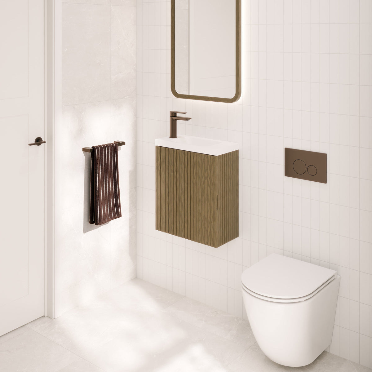 Modern bathroom vanity setup with a white wall-mounted sink cabinet, dark bronze faucet and flush plate, a tall rectangular mirror with warm lighting, a white toilet, and a dark striped towel on a white tiled wall.