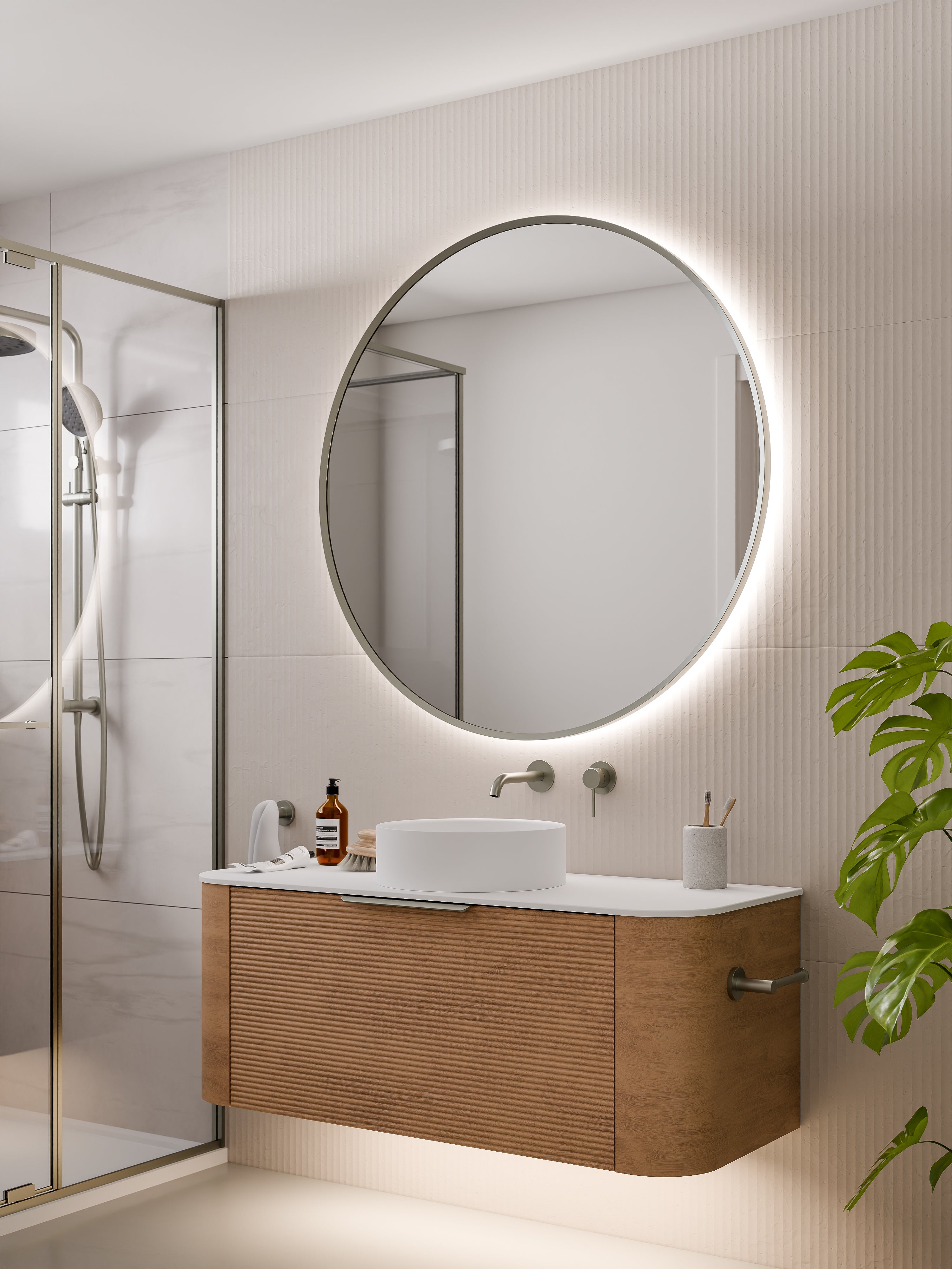 round-framed-led-mirror-in-brushed-nickel-with-curved-vanity-in-bathroom-setting