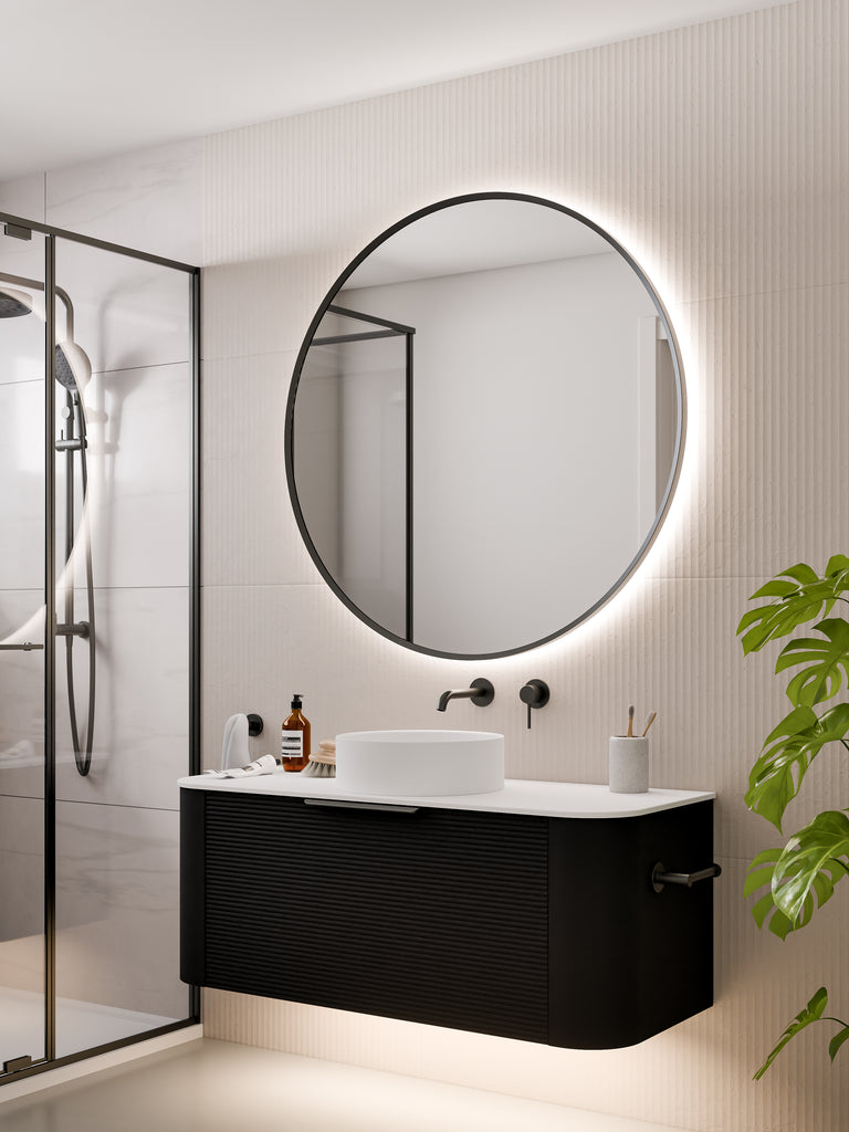 round-framed-led-mirror-in-gunmetal-with-curved-vanity-in-bathroom-setting