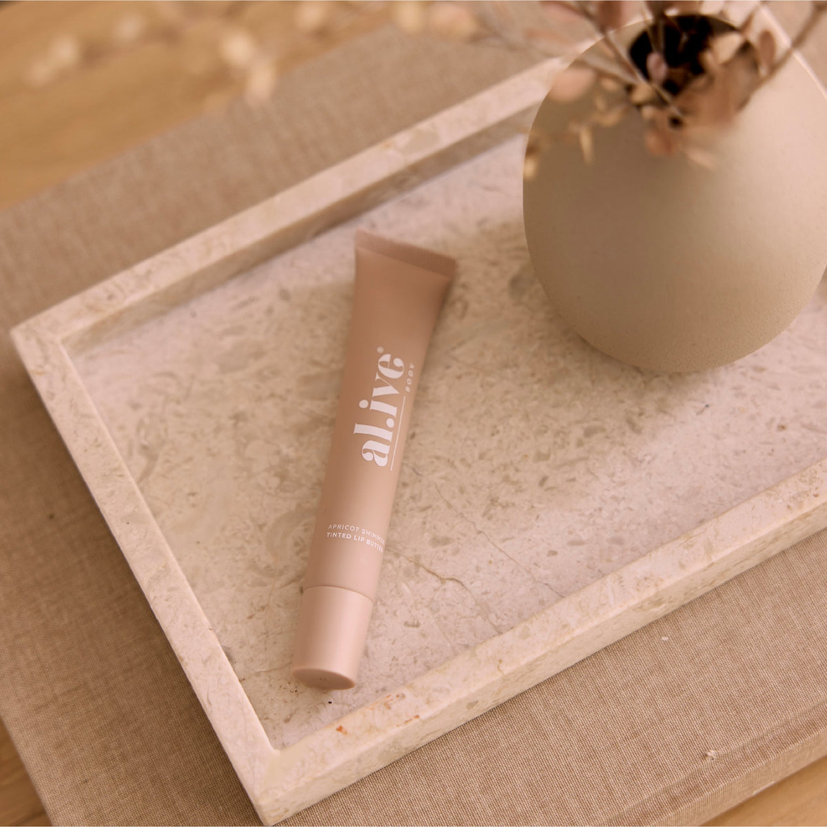 al.ive body Tinted Lip Butter Apricot Shimmer - lifestyle shot