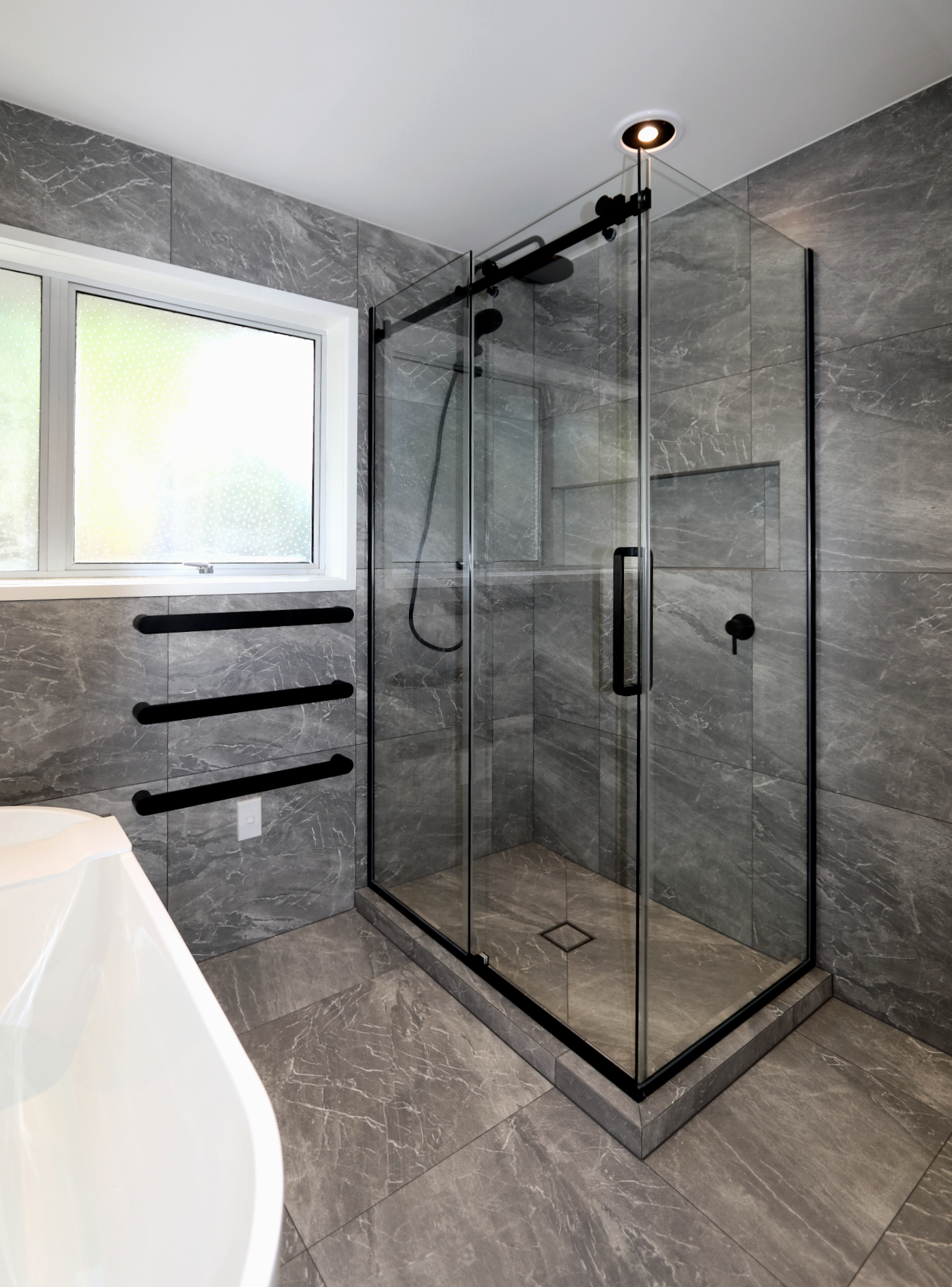 luxury-tiled-shower-with-glass-sliding-door-in-bathroom-setting